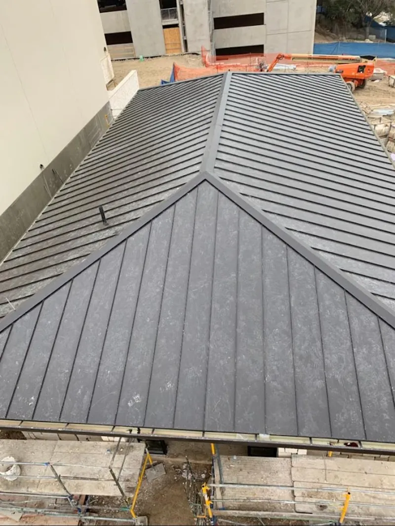 Commercial metal roof construction with crane equipment in Midway